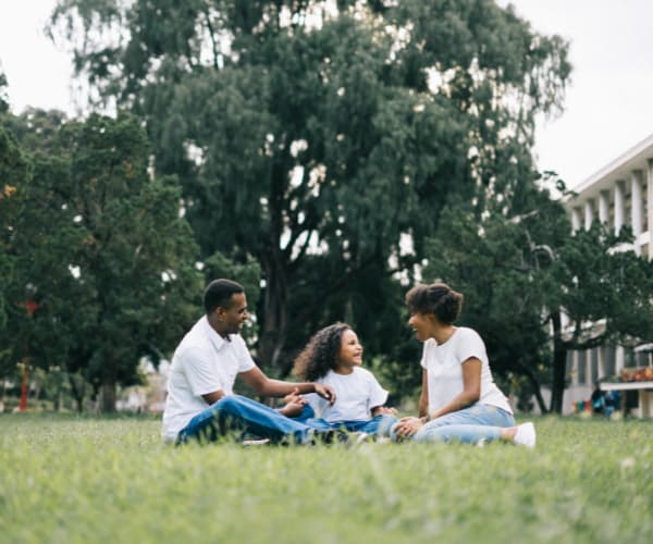 African American family sits down for a picnic at the park